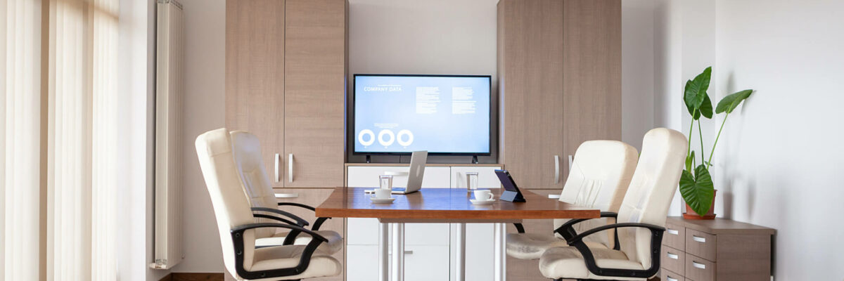 Empty conference room in business center with a TV in background Empty conference room in business center. There is a TV displaying some graphs and charts on the background